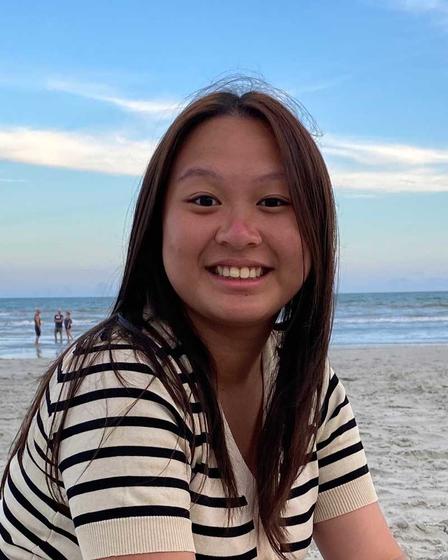 Break Through Tech 2023 Sprintern Nhu Vo smiles at the camera while at the beach at sunset